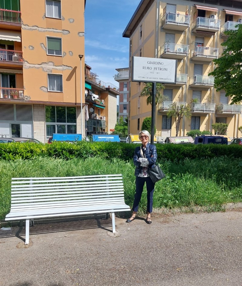 Antonella Pazzaglia sotto la targa del giardino dedicato al marito e sulla panchina bianca