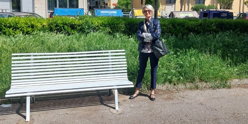 Antonella Pazzaglia davanti alla "panchina bianca dedicata a Remo Petroni