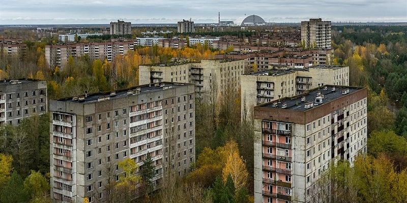 1986 - Disastro nucleare a Chernobyl . Veduta di Pryp"jat' con il nuovo sarcofago della centrale nucleare di Černobyl' sullo sfondo (2019).
