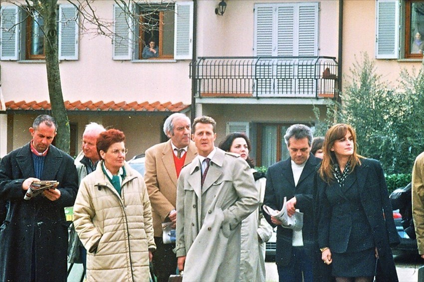 Il grande pilota della Ferrari al centro del gruppo di comparse.