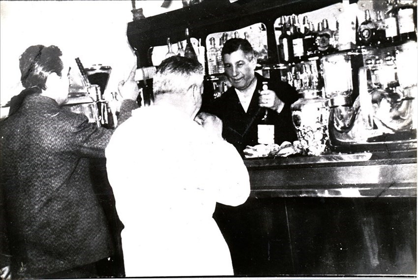 Settembre 1959. Ugo Ballini dietro al banco mentre serve  un “wermuttino” ad Amilcare Giovannini detto “l’avvocatino” a sinistra e Gino Costi detto “pedalino”a destra.