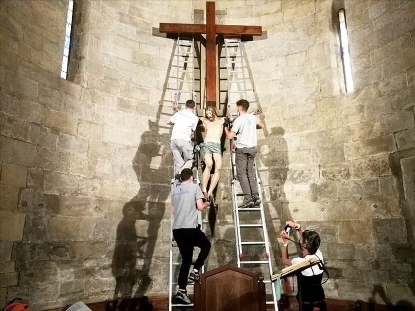 I tecnici iniziano a ricollocare la statua sulla Croce davanti all’abside della Pieve.