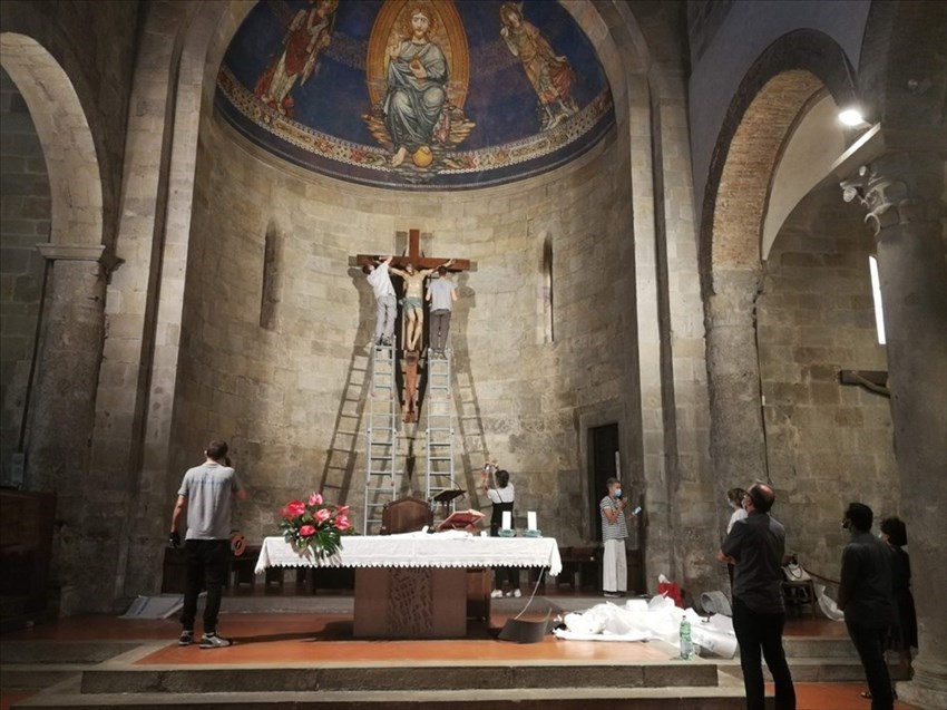 Funzionari, tecnici e i sacerdoti osservano la conclusione del ricollocamento del cinquecentesco Crocifisso.