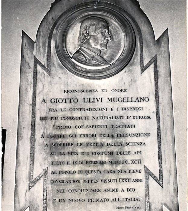La lapide all’interno della Chiesa di Santo Stefano a Campi Bisenzio che ricorda don Giotto Ulivi, con in alto il suo volto in basso rilievo