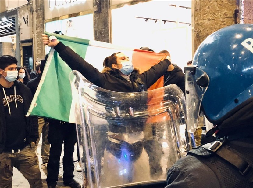 Manifestante che alza al cielo la bandiera italiana