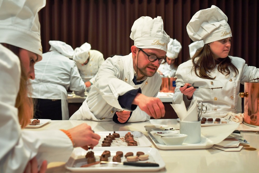 I bambini di Trisomia 21 alla fabbrica di cioccolato. Foto del giorno