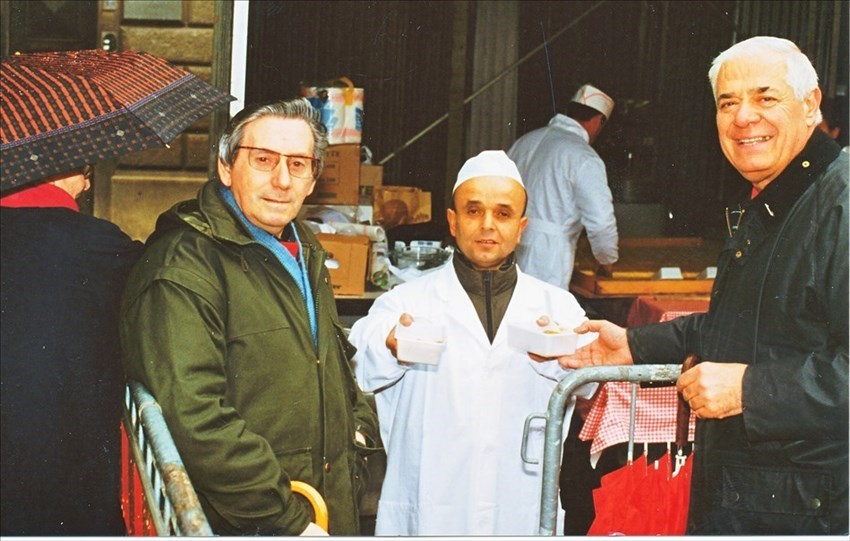 Enzino Spoglianti al centro, mentre porge la polenta a Giovanni Giovannini e Franco Dallai.