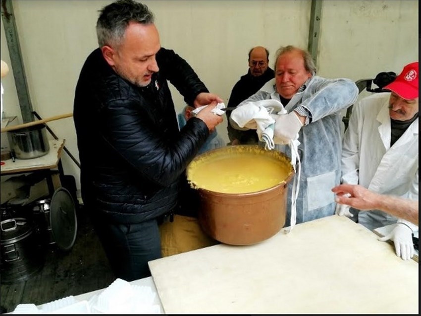 La fatica dei polentai nell’innalzare il grosso piauolo sullo spianattoio