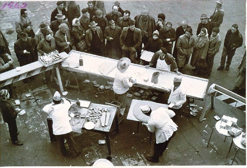 Una polentata di altri tempi, sul tavolo a sinistra si nota una cassetta di aringhe.