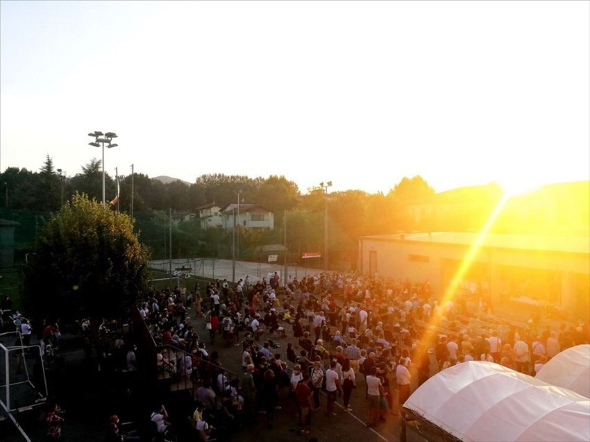 Il sole tramonta e inizia a scendere il buio, ma la gente resta al suo posto fino al termine.