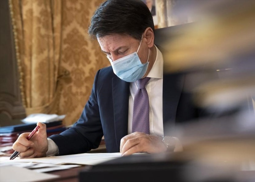 Giuseppe Conte che firma il dpcm