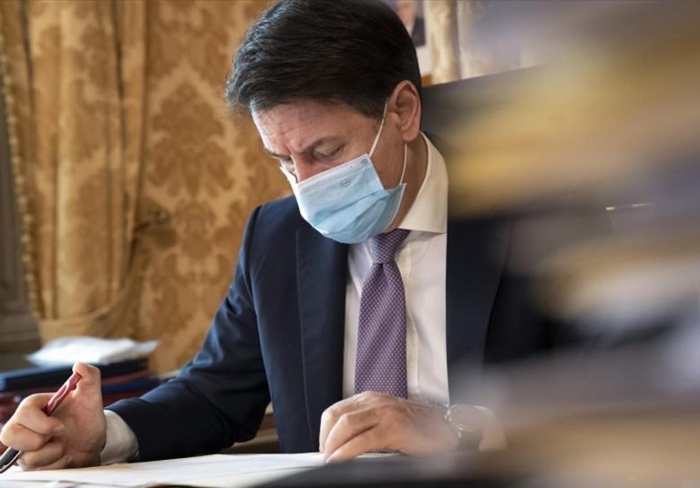 Giuseppe Conte che firma il dpcm