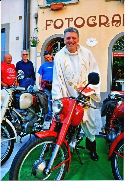 Una immagine particolare e simpatica, il pievano di Barberino don Stefano Ulivi, sopra una moto d’epoca.