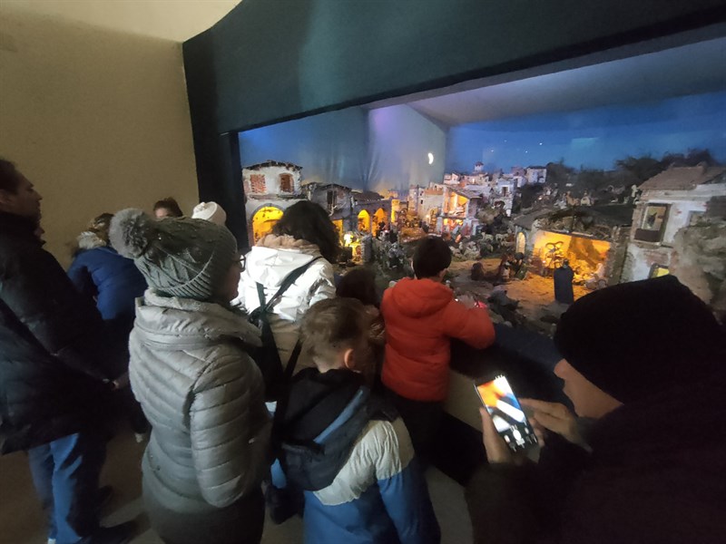 Genitori con i loro bambini davanti al presepe