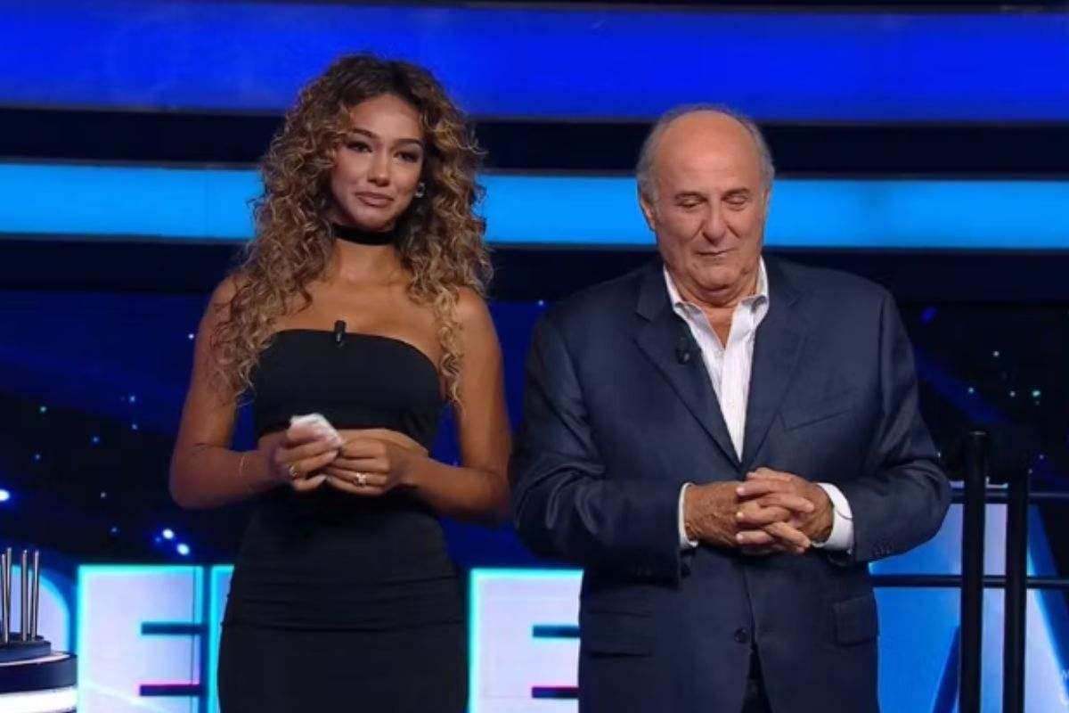 Gerry Scotti visibilmente commosso in studio con Samira Lui durante la puntata de La Ruota della Fortuna, mentre ringrazia la showgirl per le parole spese a Verissimo.